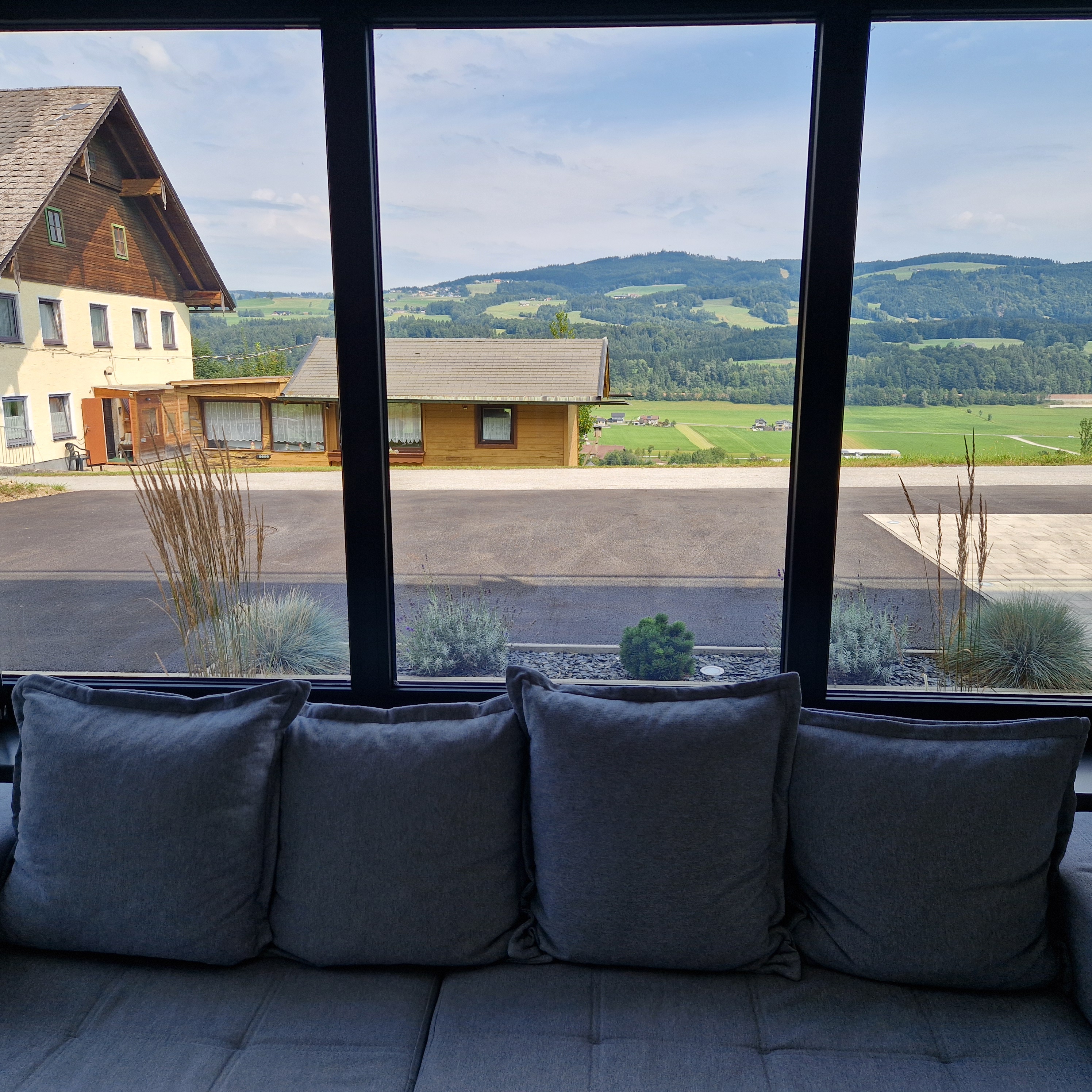 Sofa with panoramic valley view through floor-to-ceiling windows