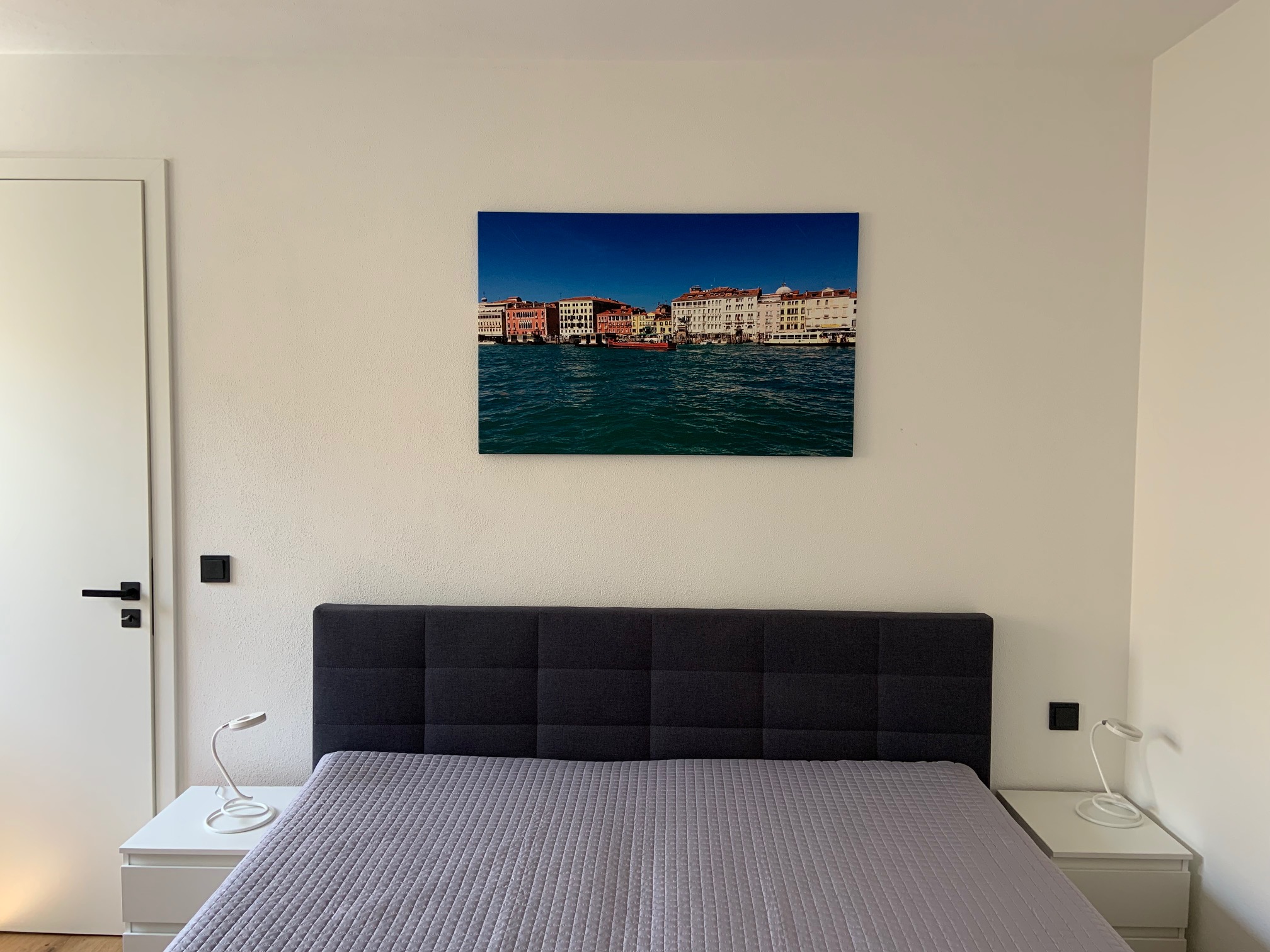 Bedroom with double bed and artwork